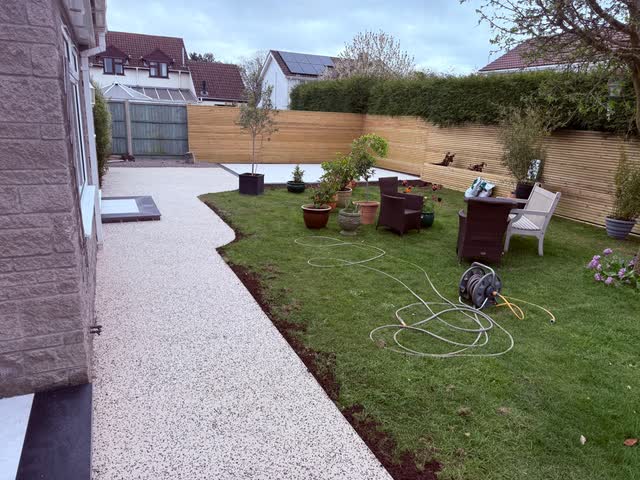 Garden after pale paths and timber screening were added around the lawn