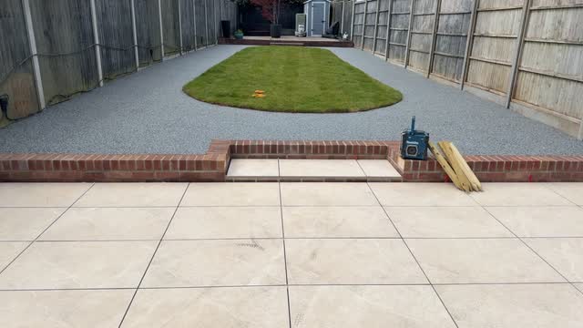 Long garden after grey surfacing was laid around a central lawn and tiled patio